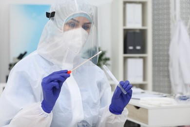 Photo of Laboratory testing. Doctor in uniform with cotton swab and tube at hospital