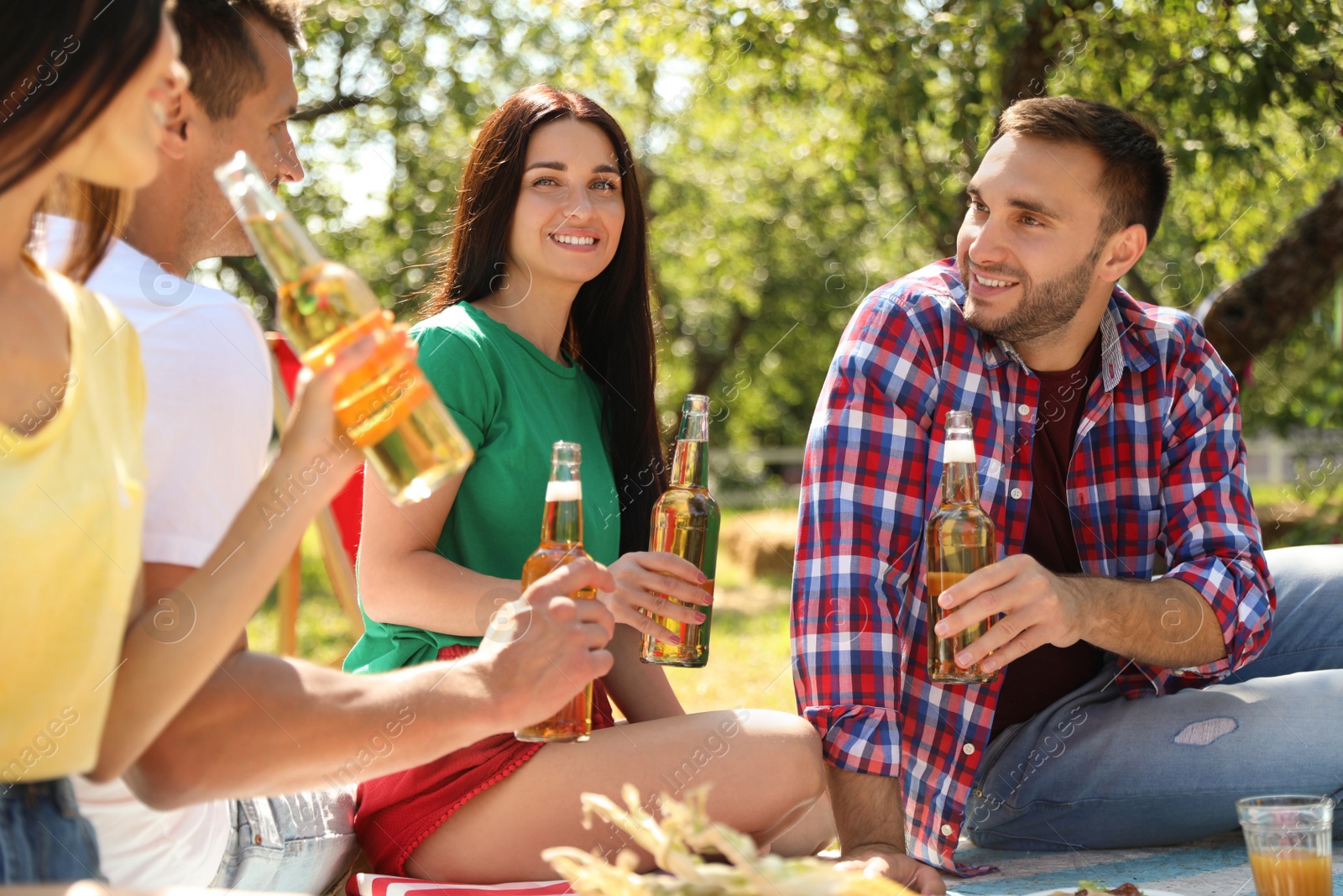 Photo of Young people enjoying picnic in park on summer day