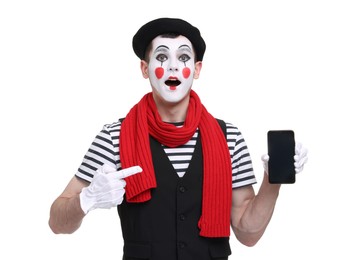 Funny mime artist pointing at smartphone on white background
