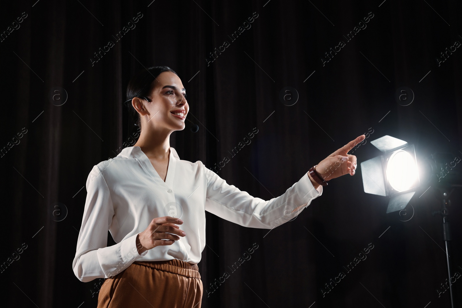 Photo of Motivational speaker with headset performing on stage