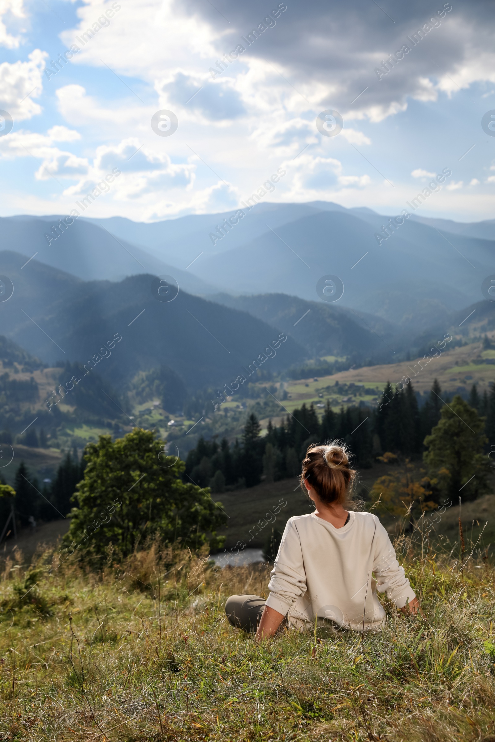 Photo of Woman enjoying beautiful mountain landscape, back view. Space for text