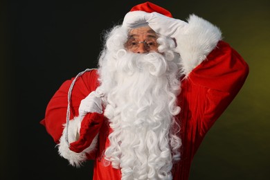 Photo of Merry Christmas. Santa Claus with bag on dark background