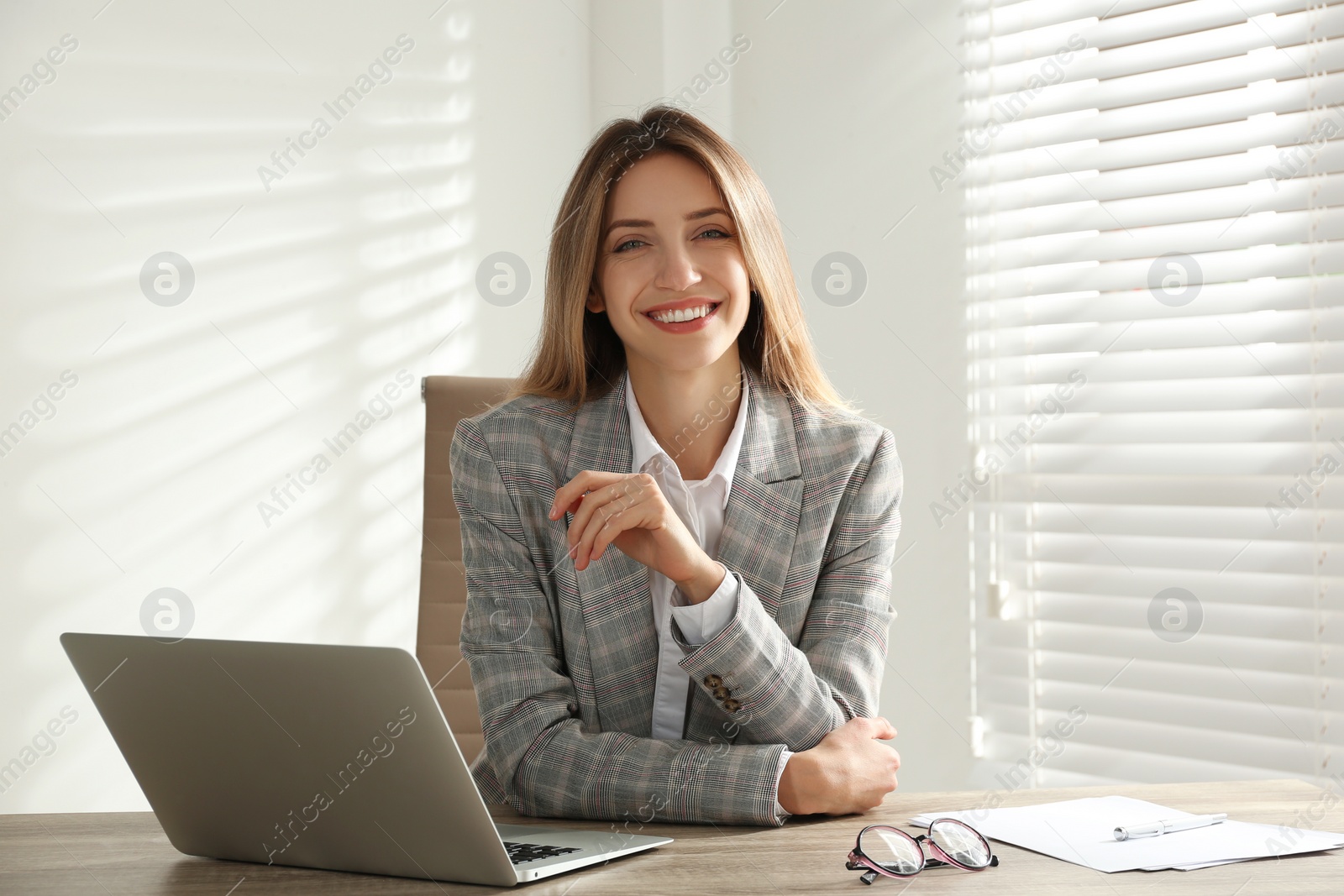 Photo of Portrait of beautiful young businesswoman with laptop at table in office