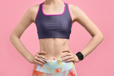 Photo of Woman in sportswear on pink background, closeup