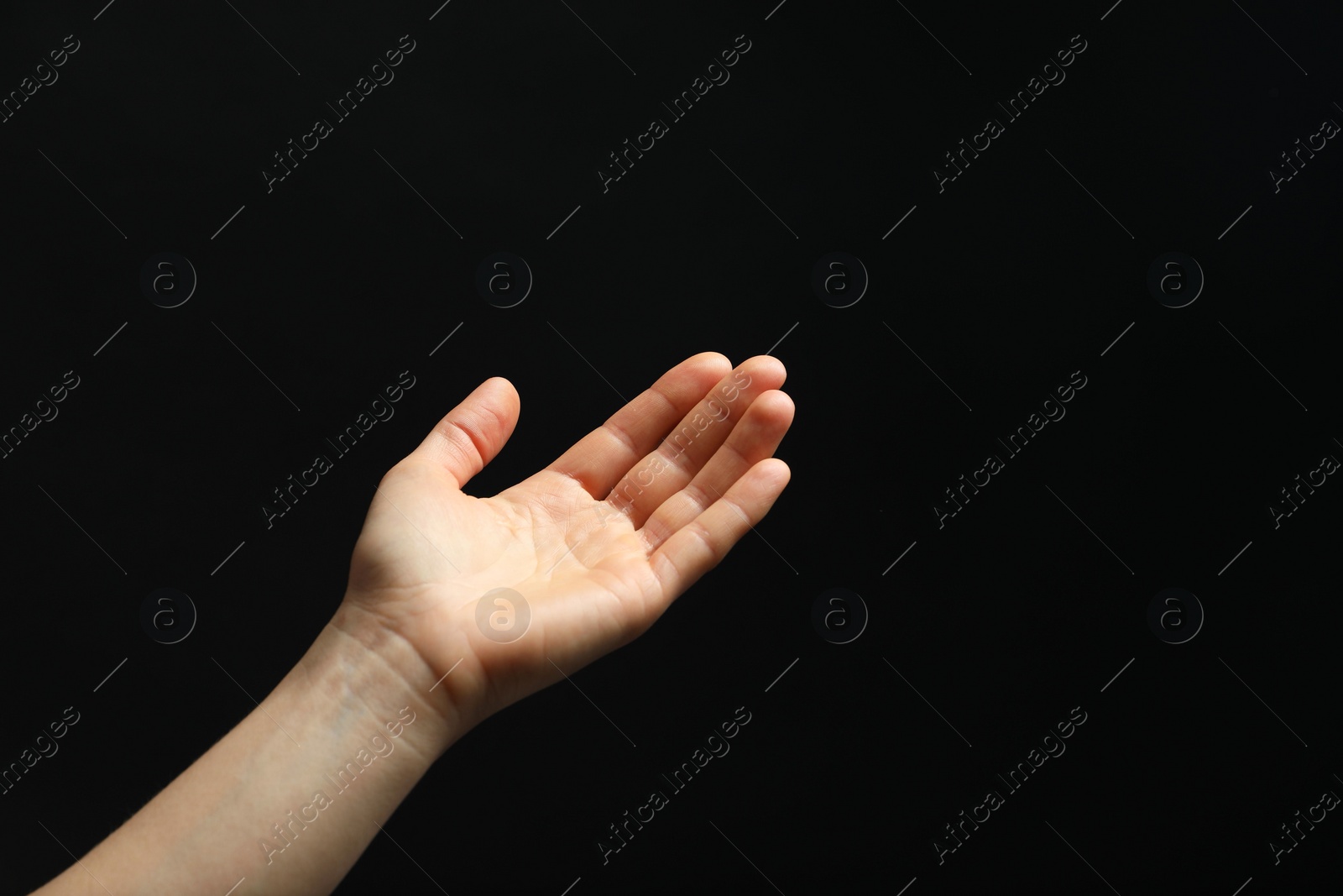 Photo of Woman holding something in hand on black background, closeup. Space for text