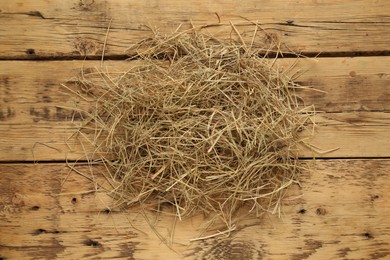 Dried hay on wooden background, top view