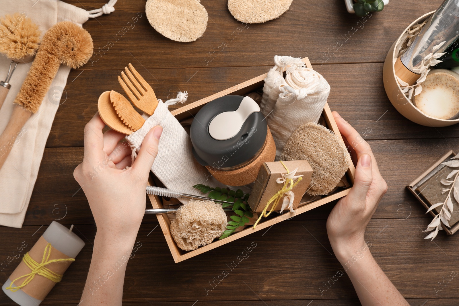 Photo of Woman with eco friendly products on wooden background, top view