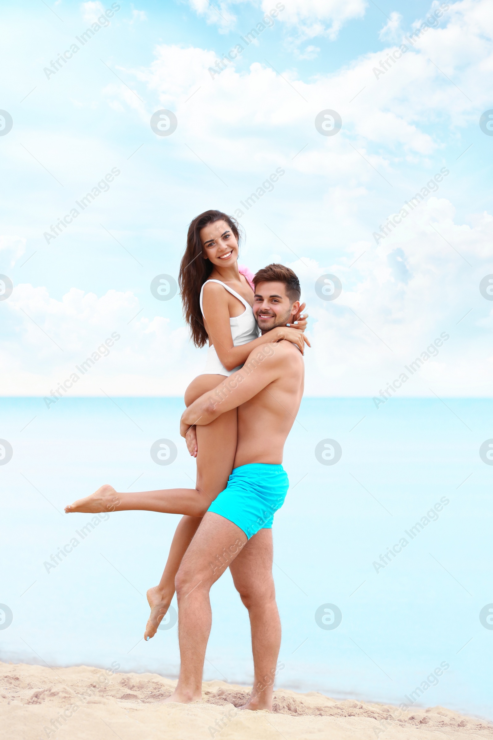 Photo of Happy young couple spending time together on beach near sea