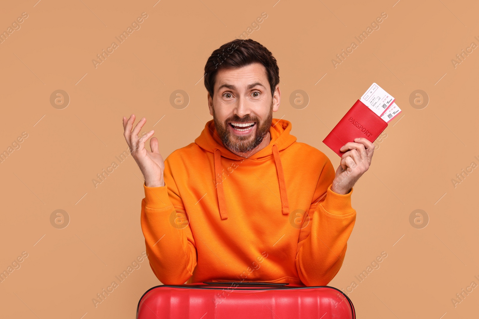 Photo of Happy man with passport, suitcase and tickets on beige background