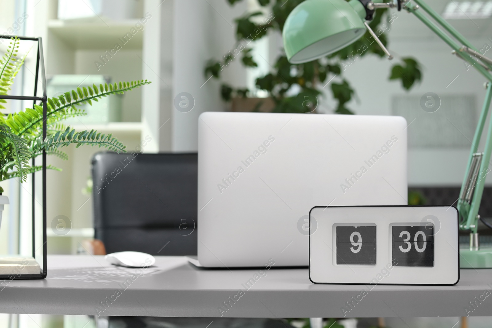 Photo of Alarm clock on table in office. Time to work