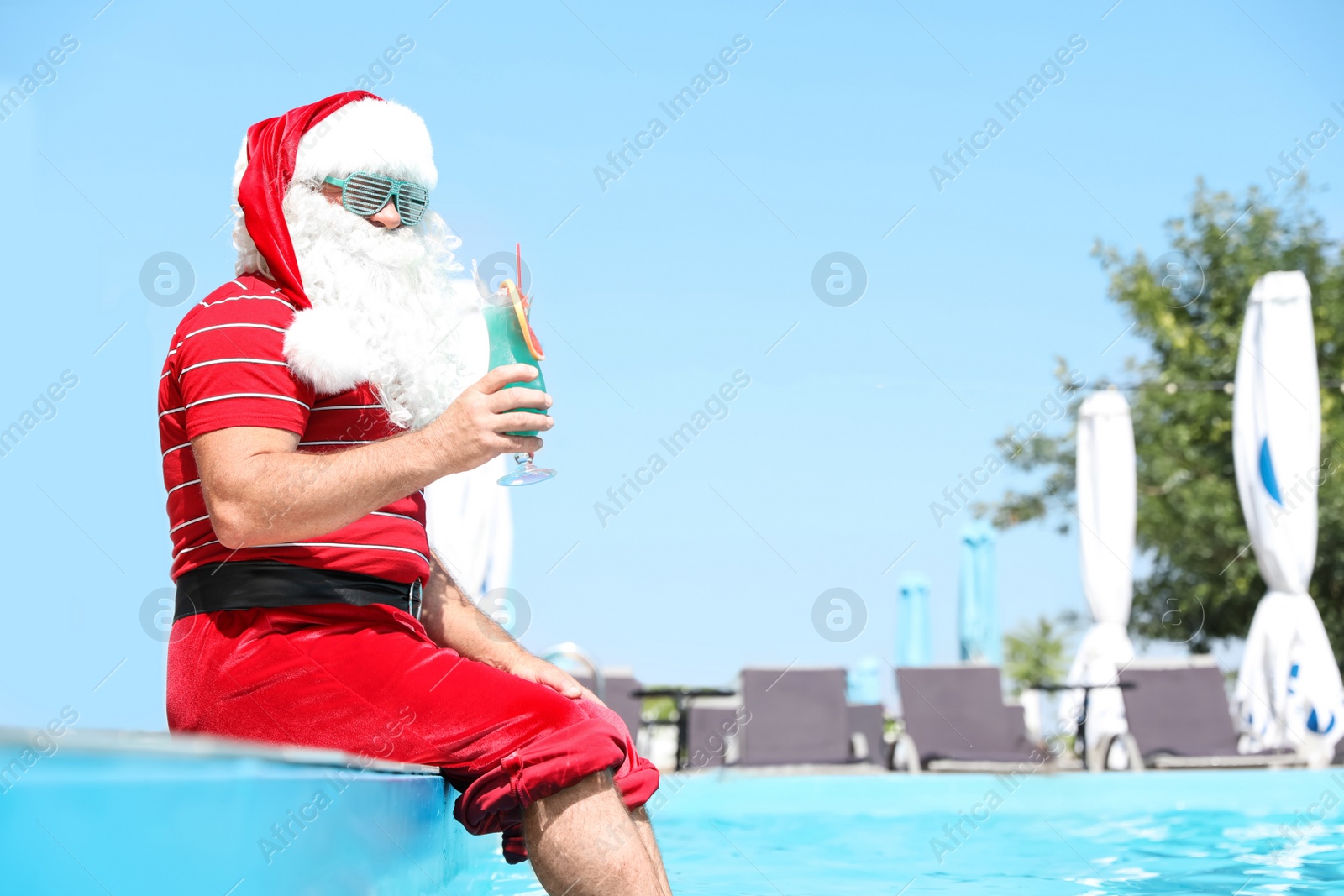 Photo of Authentic Santa Claus with cocktail near pool at resort