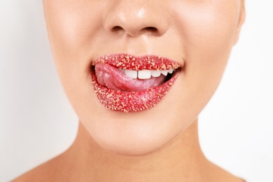 Photo of Young woman with sugar lips on white background, closeup