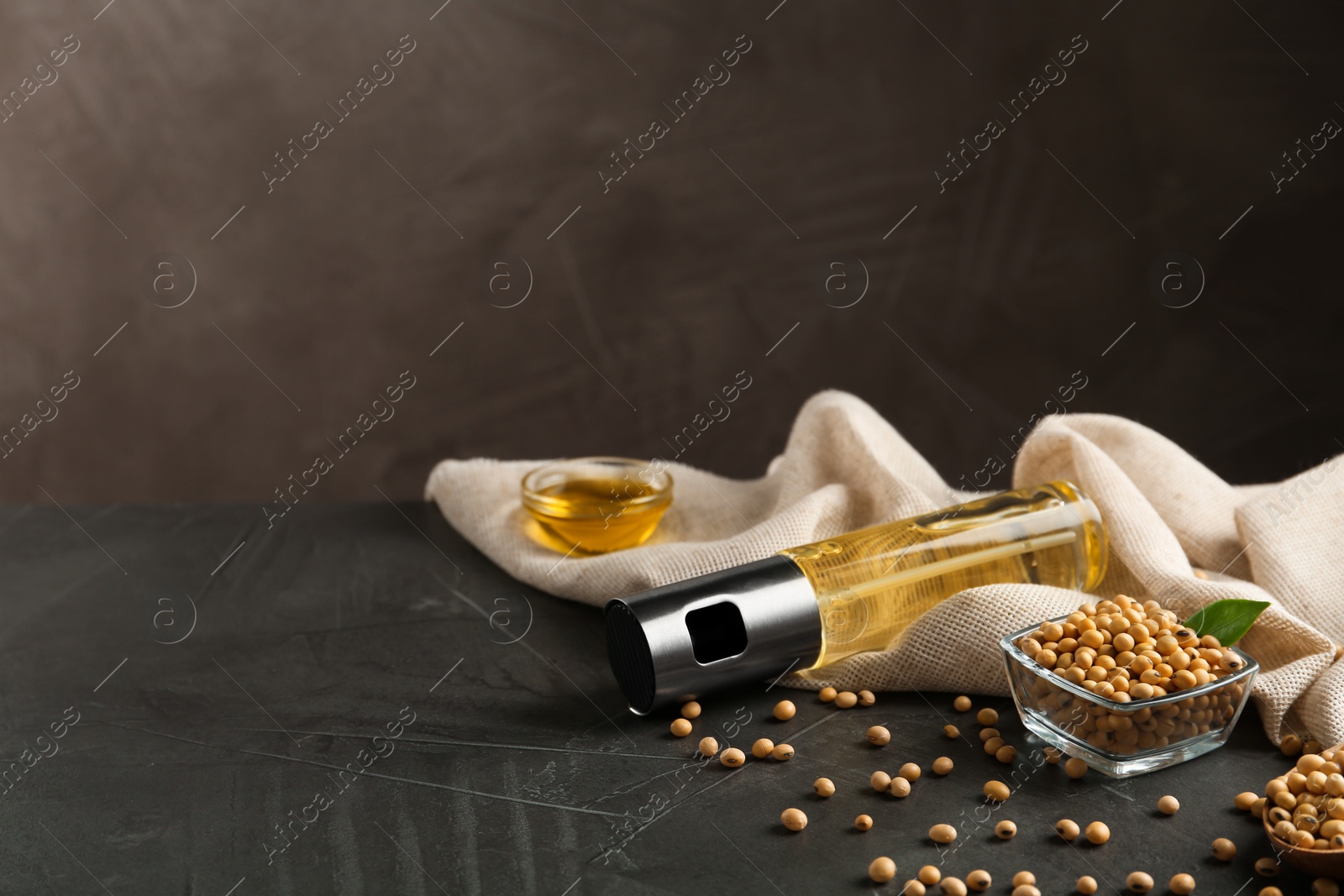 Photo of Composition with soybean oil on grey table. Space for text