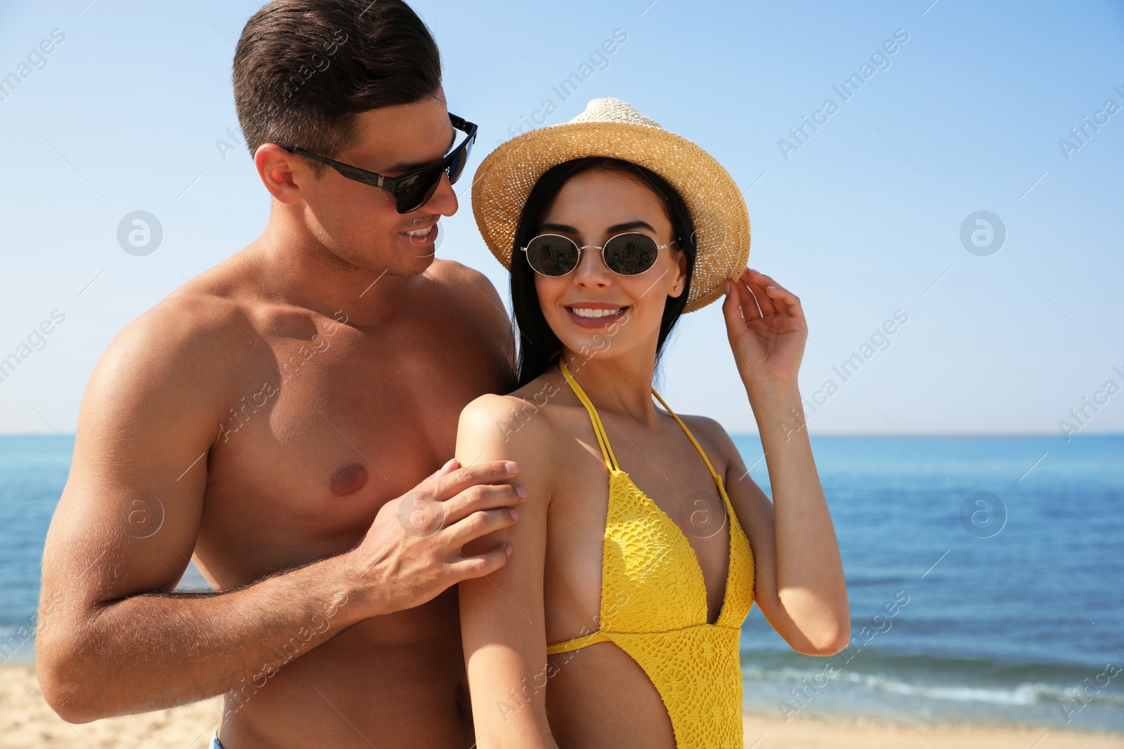 Photo of Happy couple on sunny beach at resort
