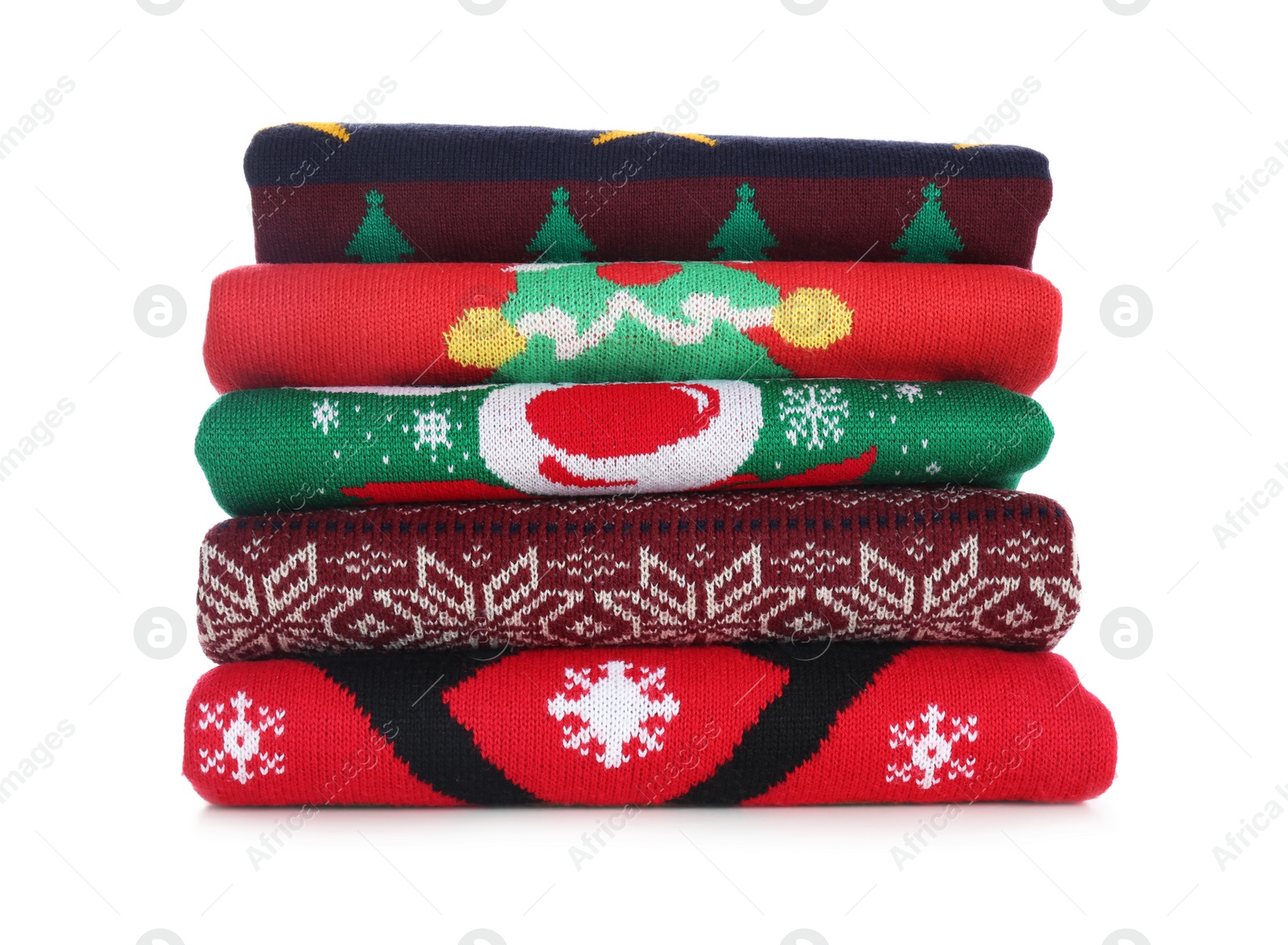 Photo of Stack of warm Christmas sweaters isolated on white