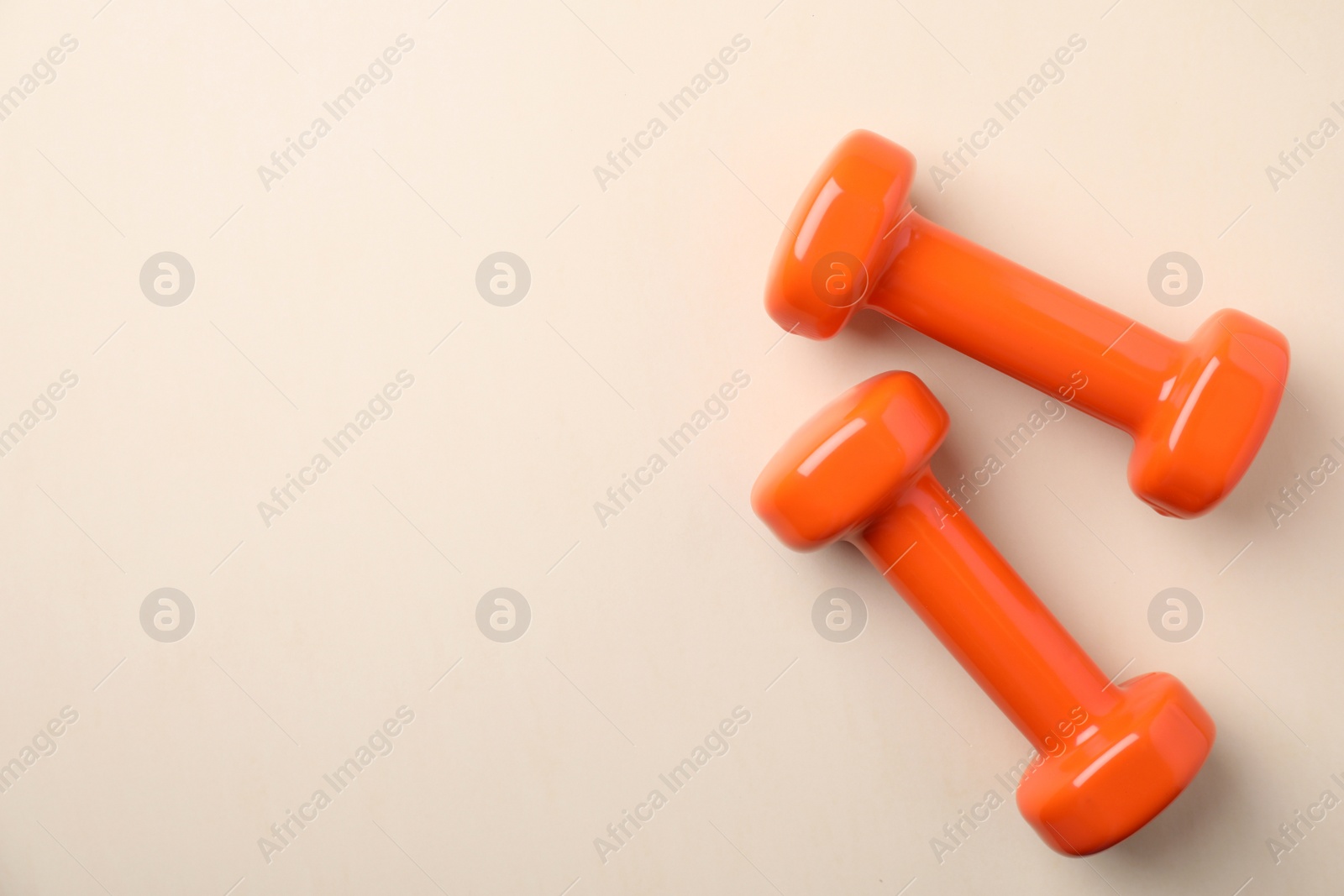 Photo of Bright dumbbells and space for text on color background, flat lay. Home fitness