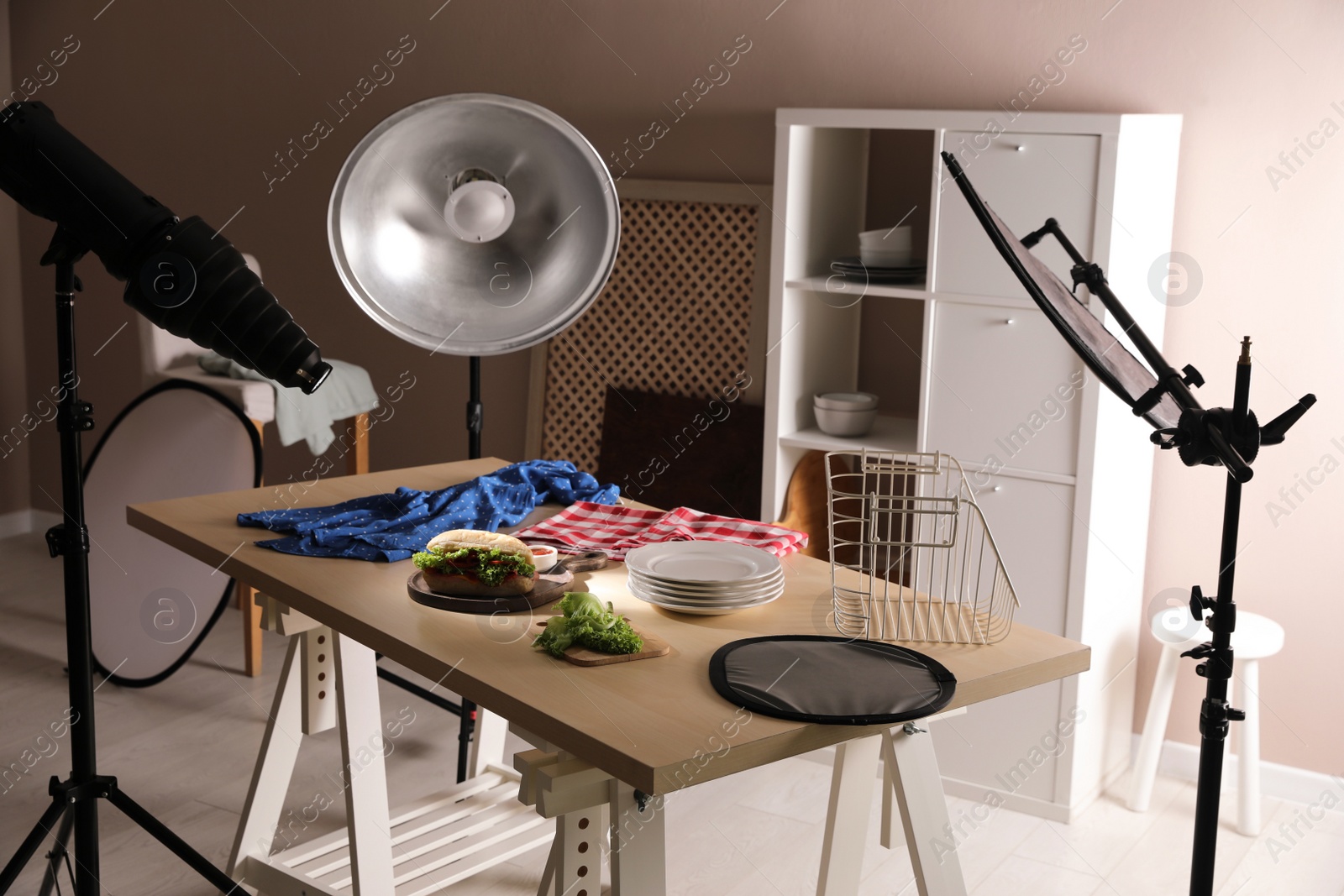Photo of Professional lighting equipment and composition with sandwich in photo studio. Food photography