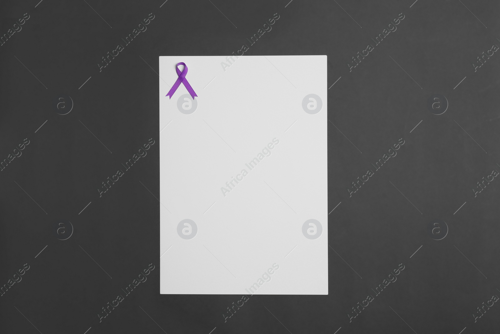 Photo of Purple awareness ribbon and blank card on black background, top view with space for text