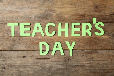 Photo of Words TEACHER'S DAY made of paper letters on wooden table, flat lay