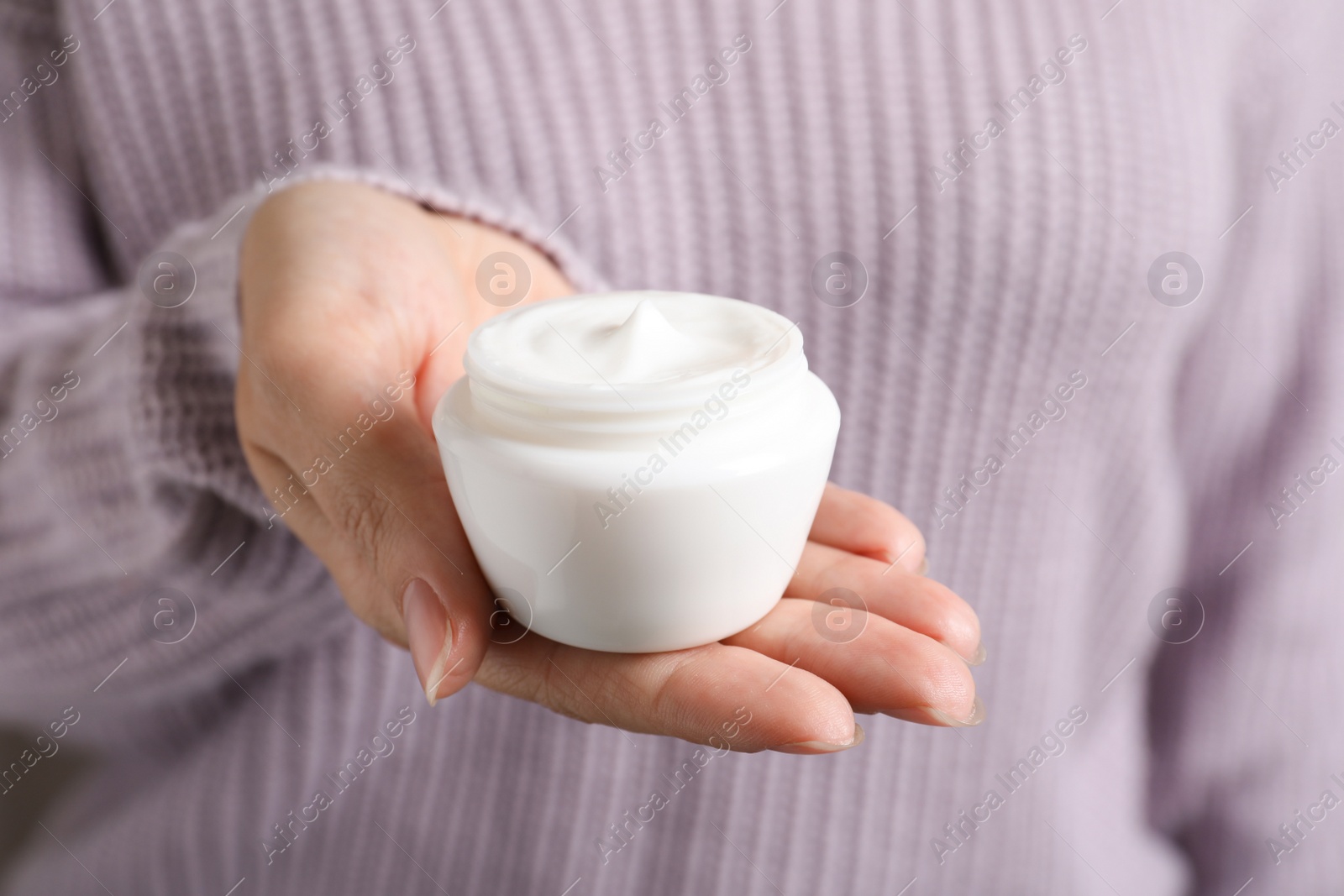 Photo of Woman holding jar of moisturizing cream, closeup. Winter skin care cosmetic