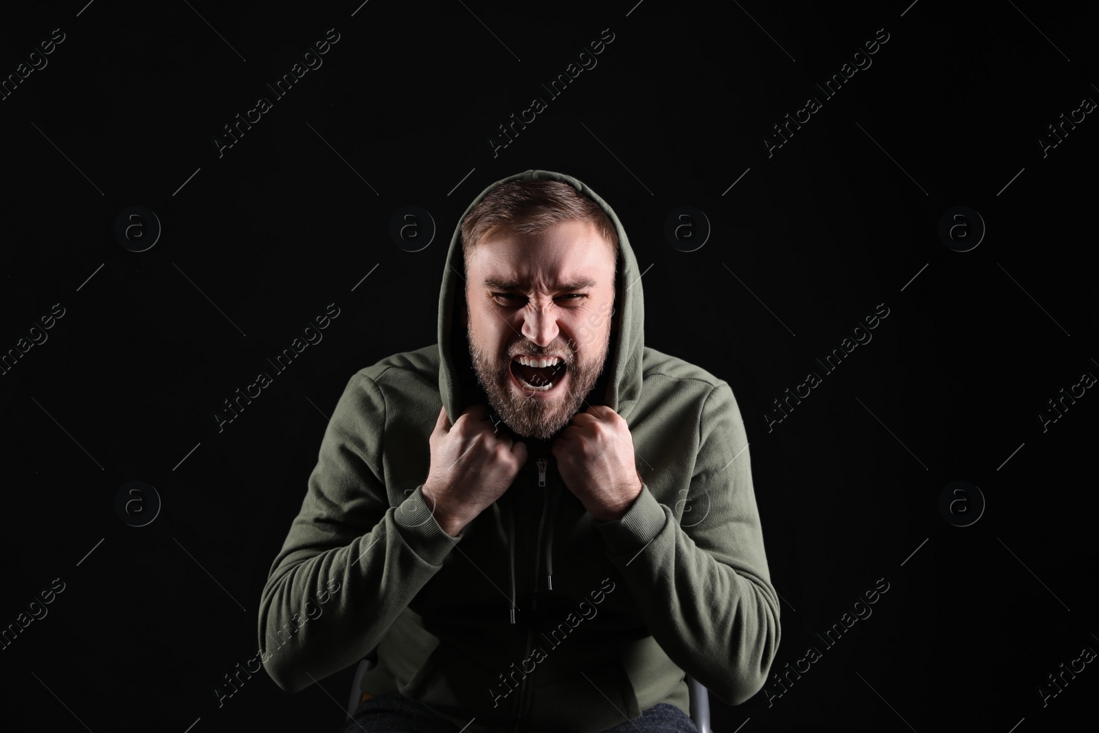 Photo of Portrait of emotional young man on black background. Personality concept
