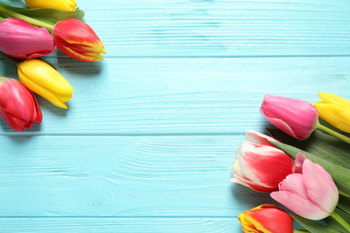 Photo of Beautiful spring tulips on light blue wooden table, flat lay. Space for text