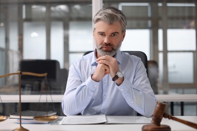 Portrait of handsome lawyer at table in office