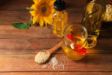 Photo of Different cooking oils and ingredients on wooden table, above view