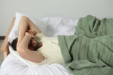 Sleepless man lying in bed at home