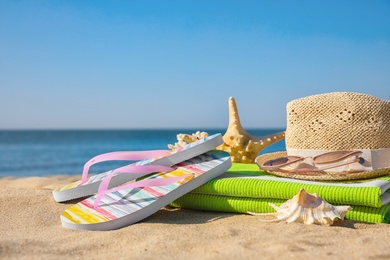 Photo of Set with stylish beach accessories on sand near sea