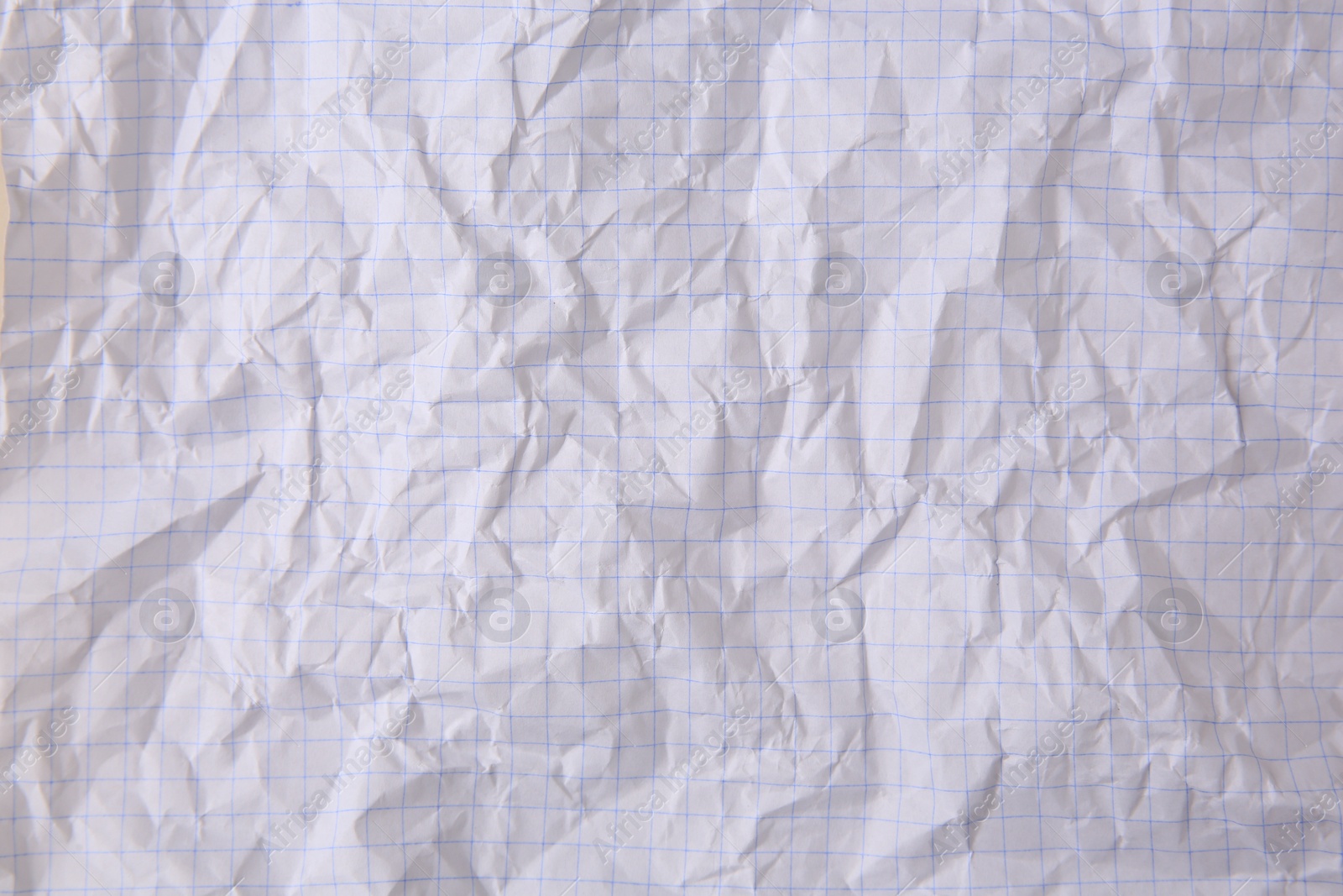 Photo of Sheet of crumpled checkered paper as background, top view