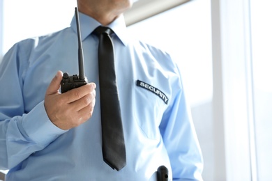 Photo of Male security guard with portable radio transmitter indoors