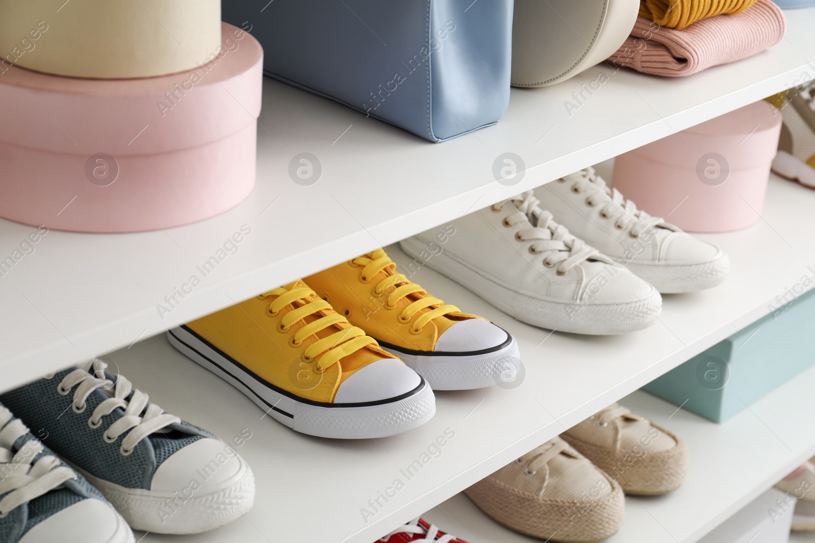 Photo of White shelving unit with collection of colorful sneakers and accessories