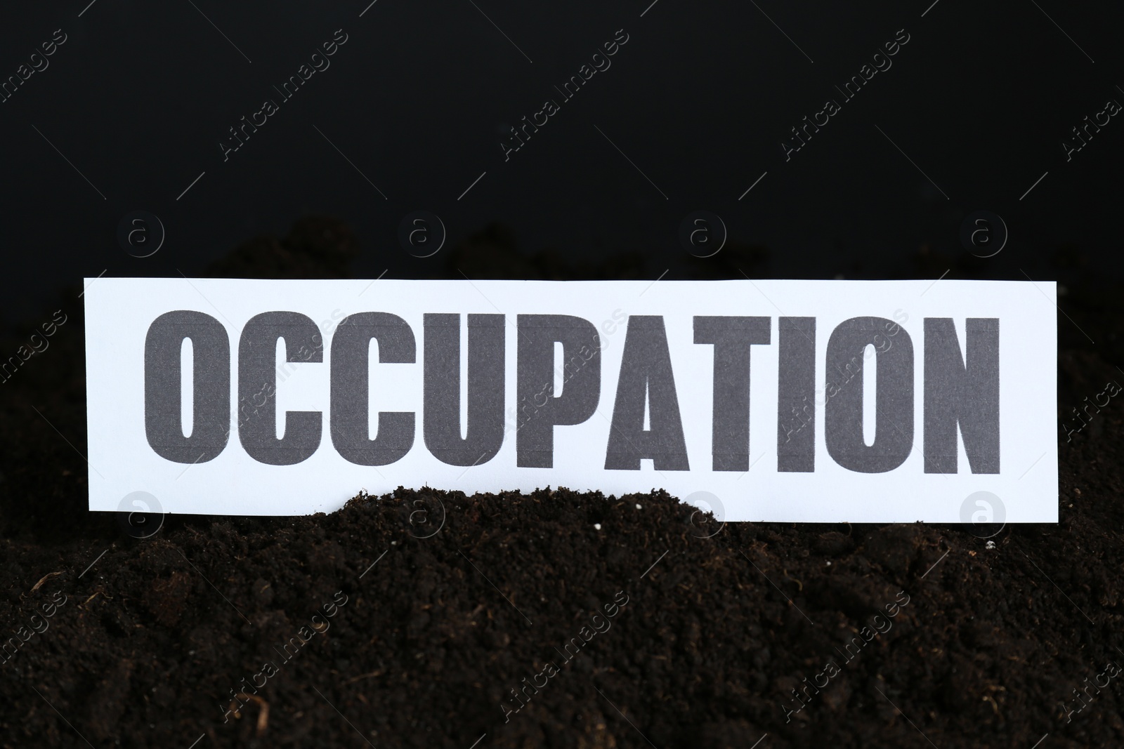 Photo of Paper card with word Occupation in soil