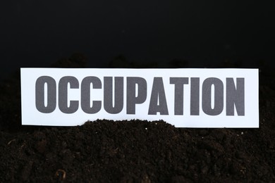 Photo of Paper card with word Occupation in soil