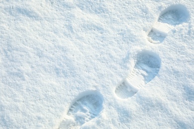 Photo of Footprints on white snow outdoors, above view. Winter season