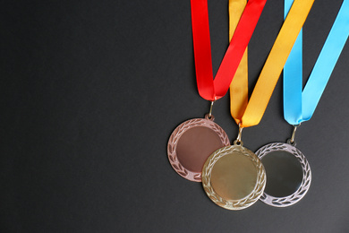 Photo of Gold, silver and bronze medals on black background, flat lay. Space for design