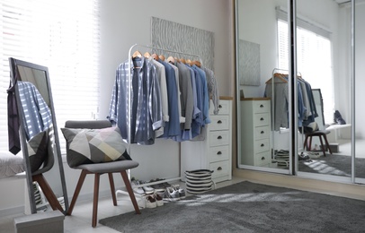 Photo of Dressing room interior with clothing rack and mirror