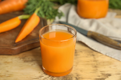 Glass of freshly made carrot juice on wooden table