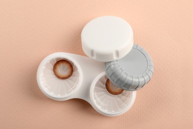 Photo of Case with color contact lenses on beige background, top view