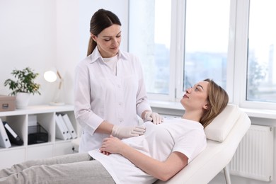 Mammologist checking young woman's breast in hospital