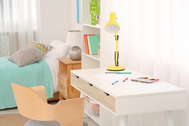 Photo of Stylish child room interior with comfortable workplace