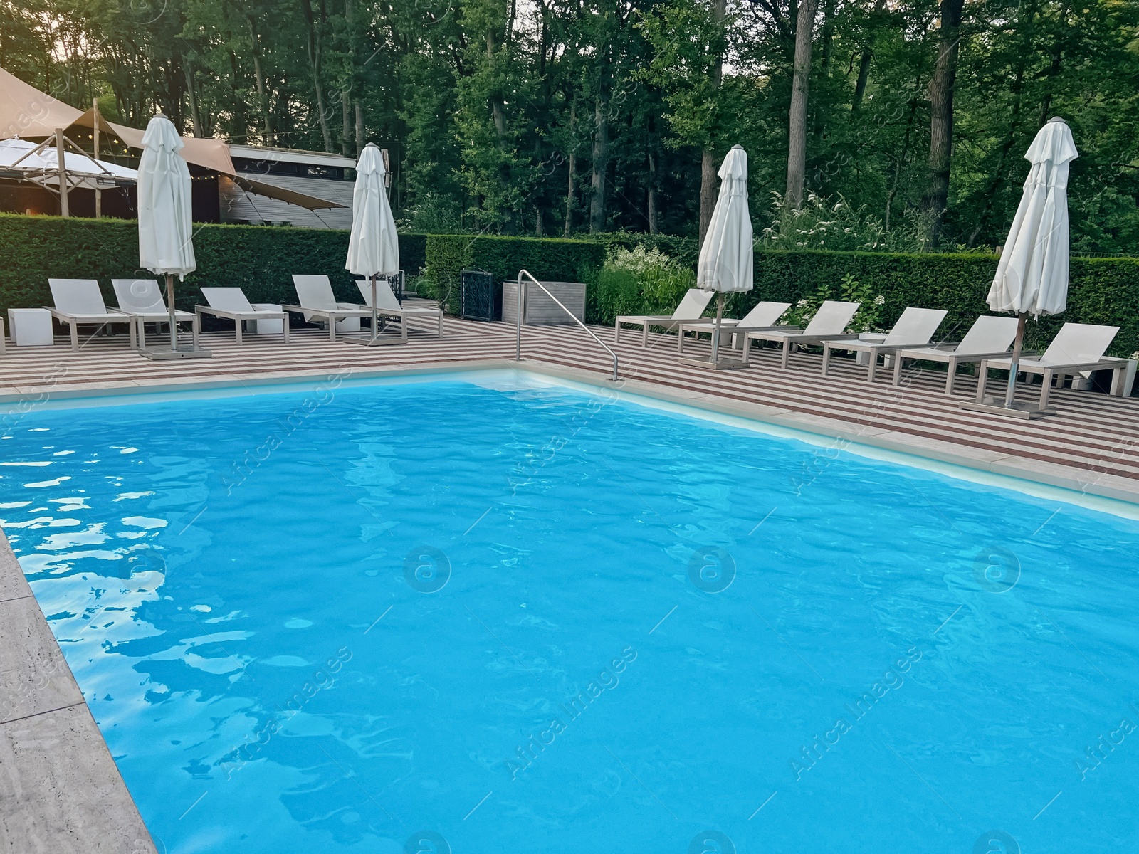 Photo of Outdoor swimming pool in luxury hotel on sunny summer day. Time for relax