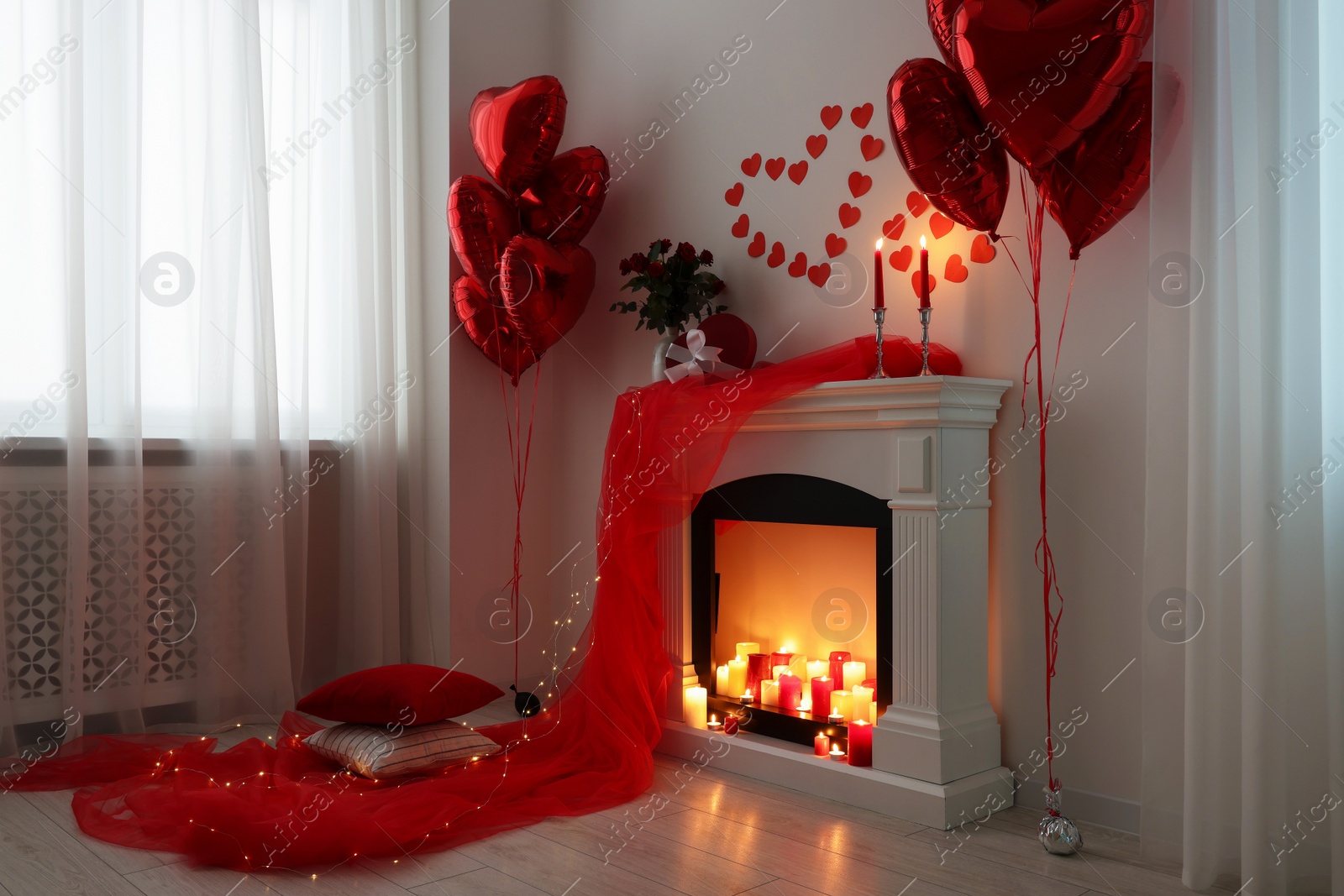 Photo of Stylish room with fireplace and Valentine's day decor. Interior design