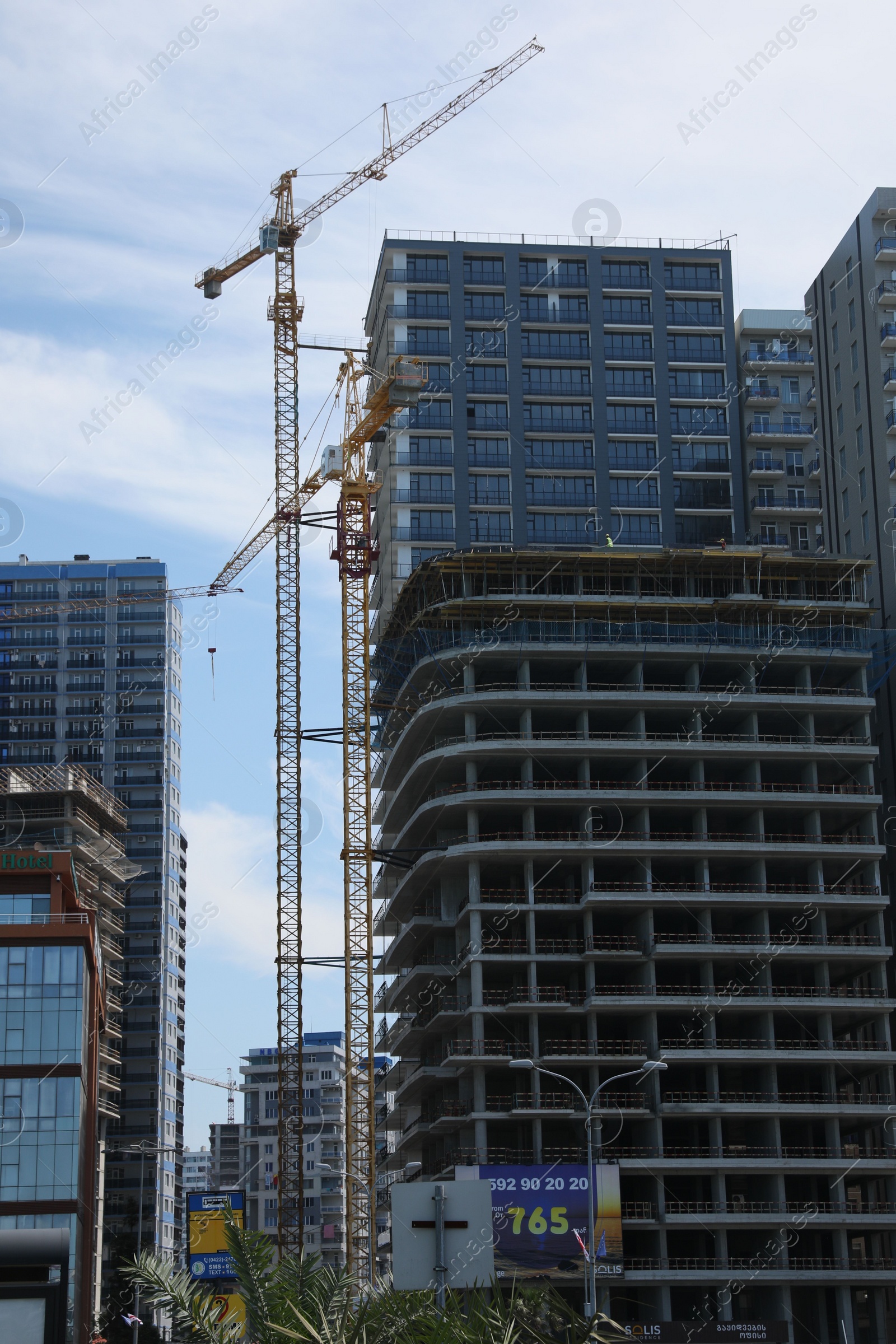 Photo of Batumi, Georgia - June 06, 2022: View of construction site with tower cranes near unfinished and modern building outdoors