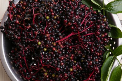 Tasty elderberries (Sambucus) on wooden table, top view