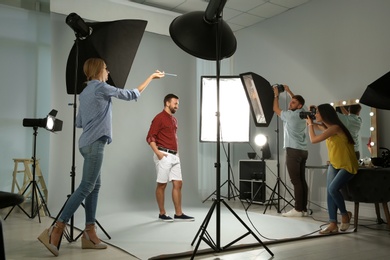 Photo of Professional team working with model in photo studio