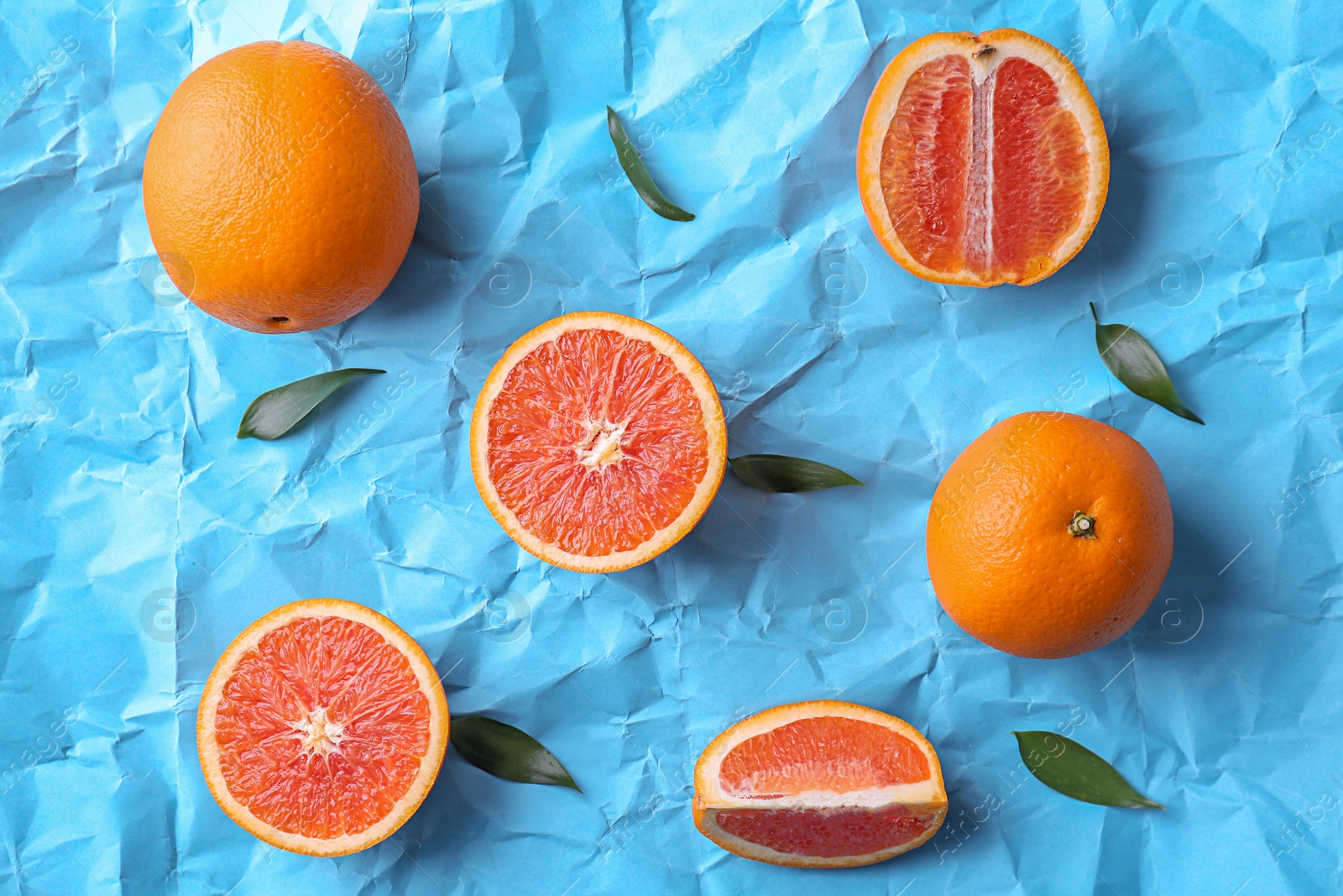 Photo of Fresh yummy oranges on color paper background