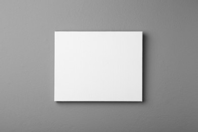 Photo of Blank canvas on grey wall. Space for design