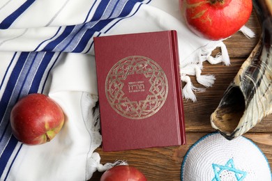 Flat lay composition with Rosh Hashanah holiday symbols on wooden table